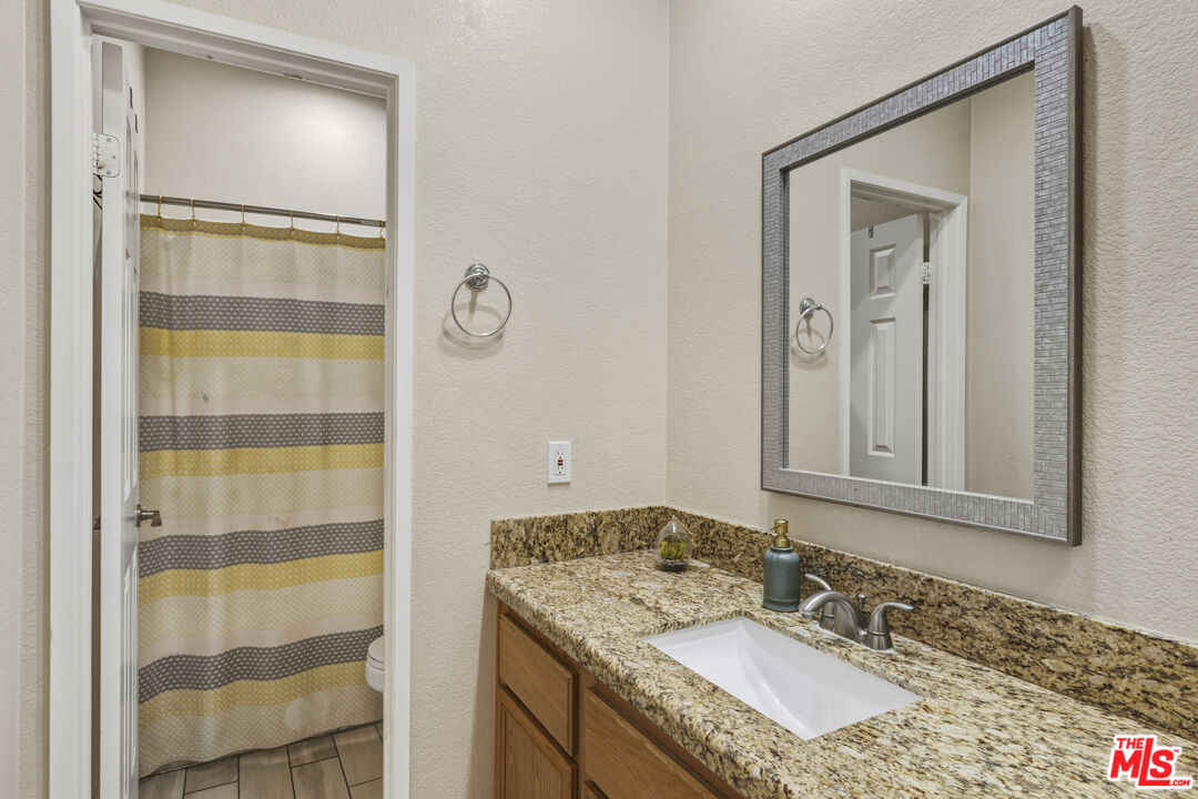 47395 Monroe Street, Unit 254 Indio, CA 92201 - Photo 17 of 21 a bathroom with a granite countertop sink and a mirror