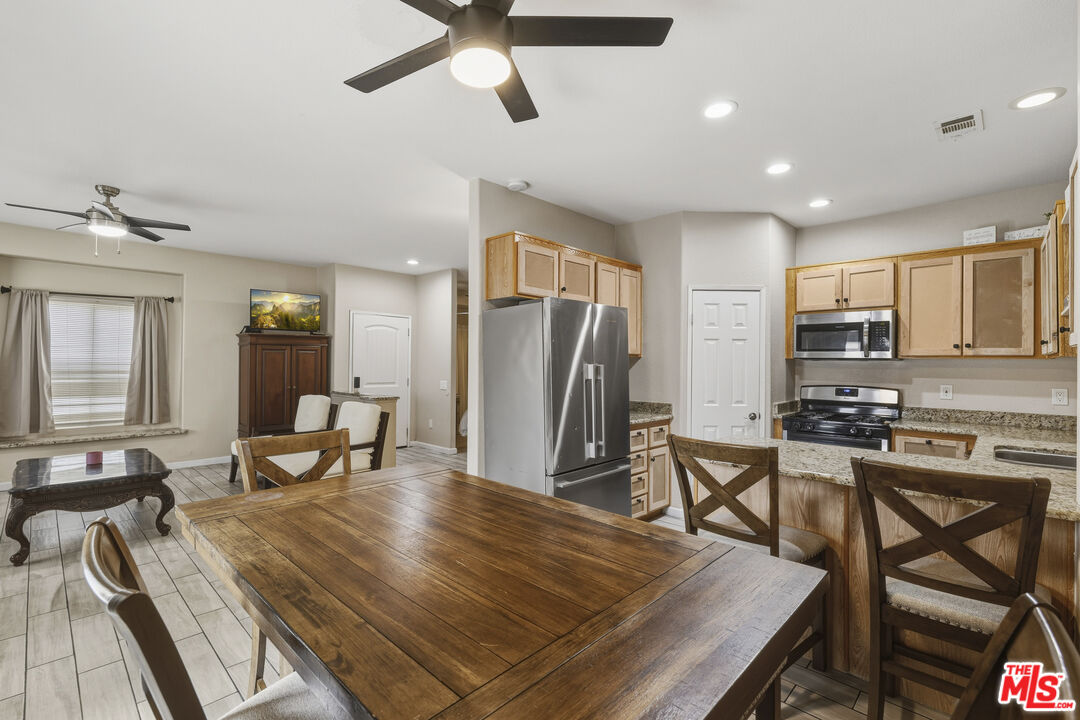 47395 Monroe Street, Unit 254 Indio, CA 92201 - Photo 9 of 21 a kitchen with stainless steel appliances granite countertop a stove a refrigerator a kitchen island a table and chairs