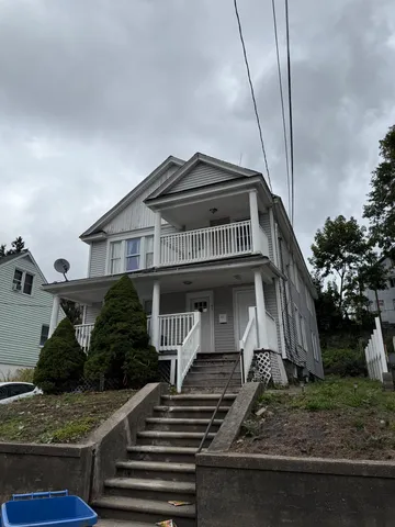 a view of a house with backyard and trees