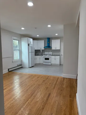 a view of kitchen with wooden floor and electronic appliances