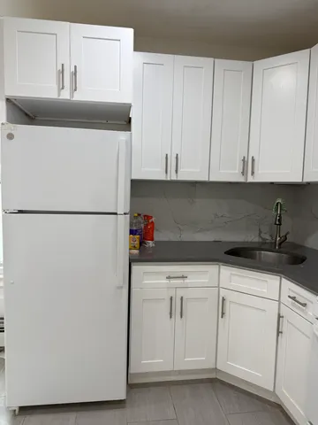 a kitchen with white cabinets and sink
