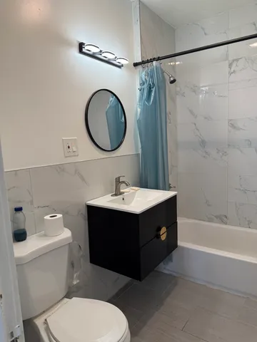 a bathroom with a sink mirror vanity and toilet