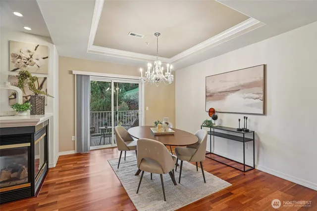 a dining room with wooden floor a chandelier a wooden table and chairs