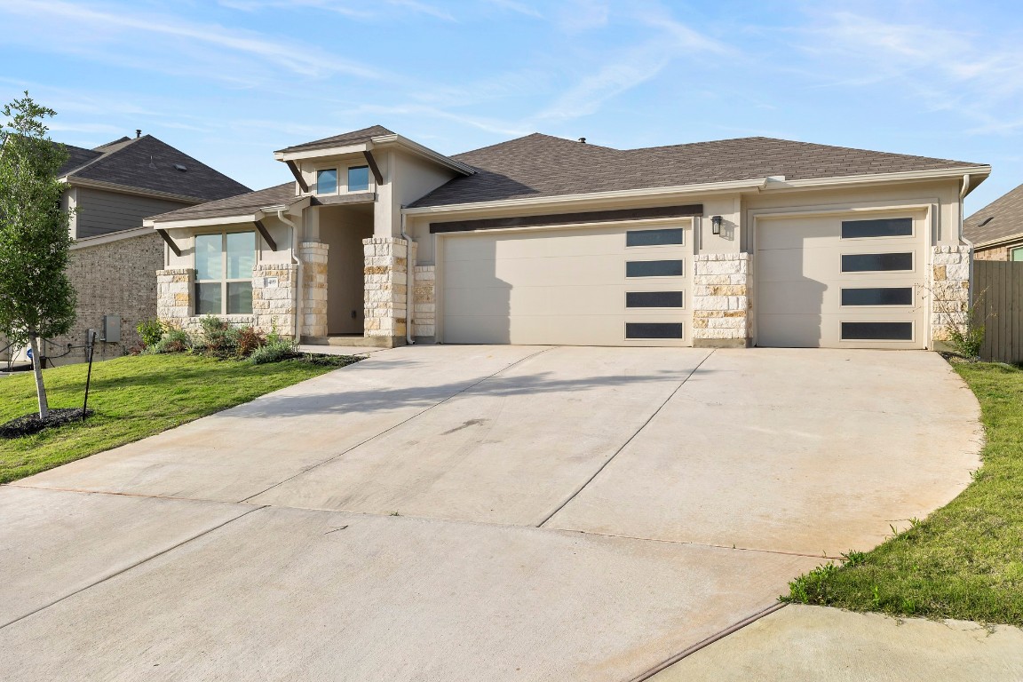 489 Cherrystone Loop Buda, TX 78610 - Photo 1 of 1 a front view of a house with a garden