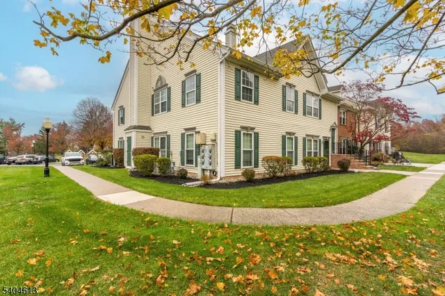 a view of a white house with a yard and plants