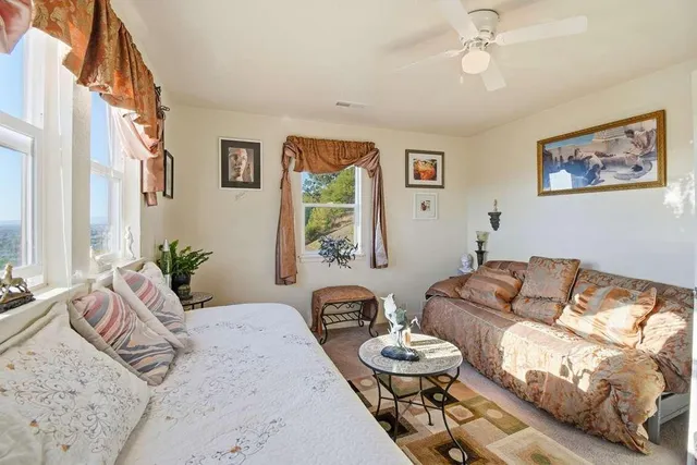 a bedroom with furniture and a large window