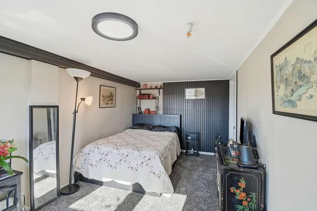 a bedroom with a bed and a painting on the wall