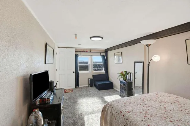 a bedroom with a bed and a flat screen tv