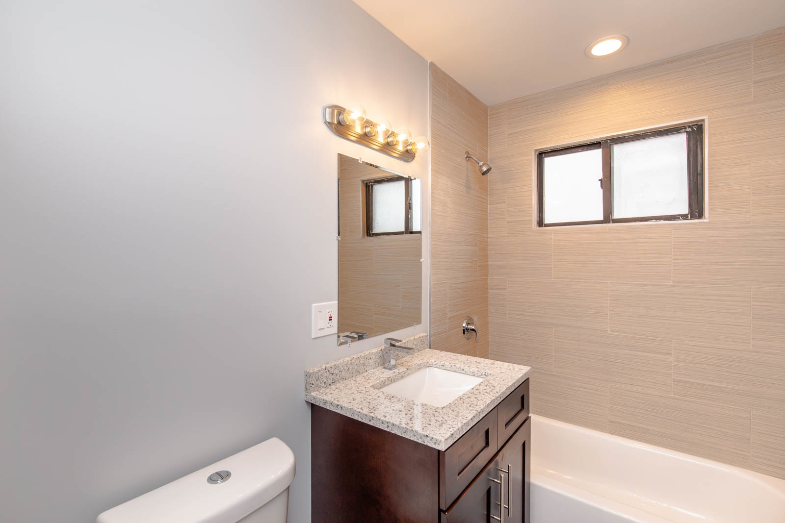 6805 North Ridge Boulevard, Unit 104 Chicago, IL 60645 - Photo 11 of 11 a bathroom with a sink a toilet and mirror