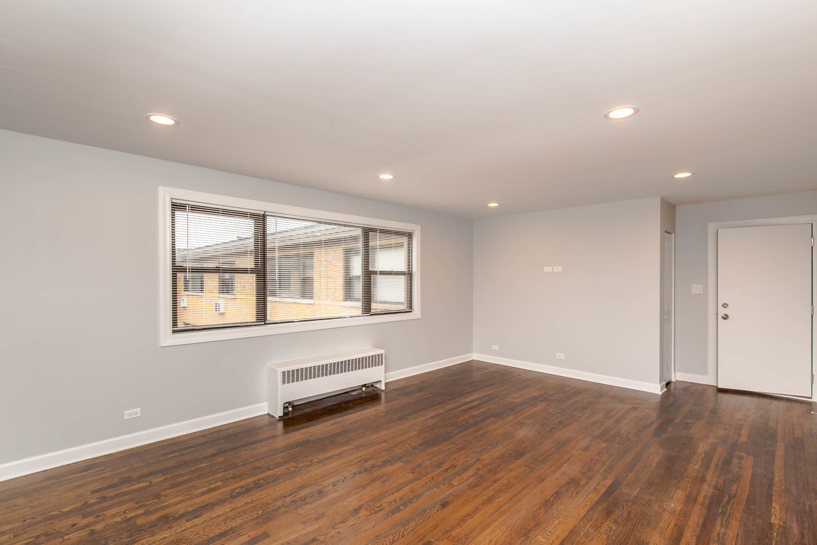 6805 North Ridge Boulevard, Unit 104 Chicago, IL 60645 - Photo 2 of 11 an empty room with wooden floor and windows