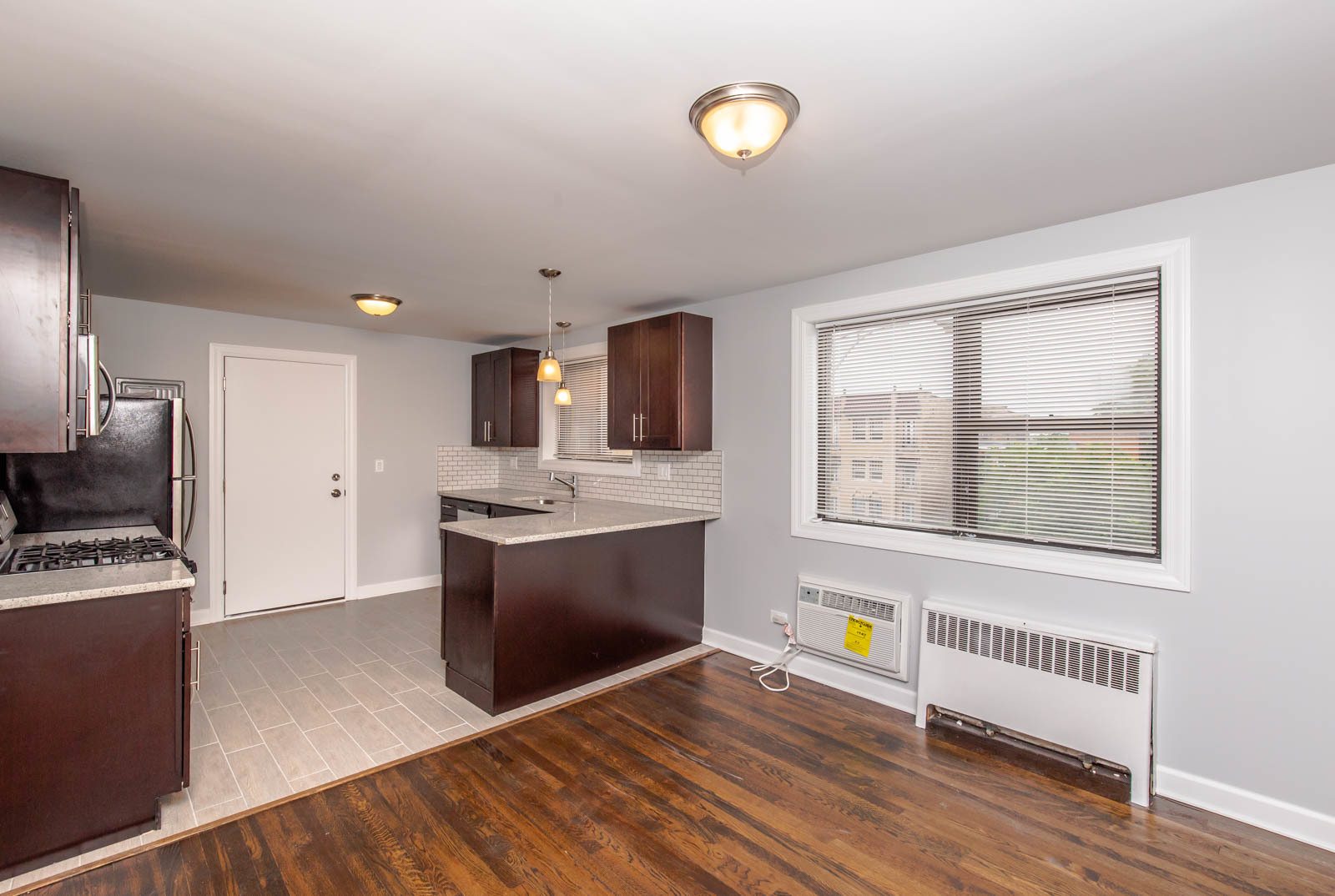 6805 North Ridge Boulevard, Unit 104 Chicago, IL 60645 - Photo 3 of 11 a kitchen with stainless steel appliances granite countertop a stove a sink and a microwave