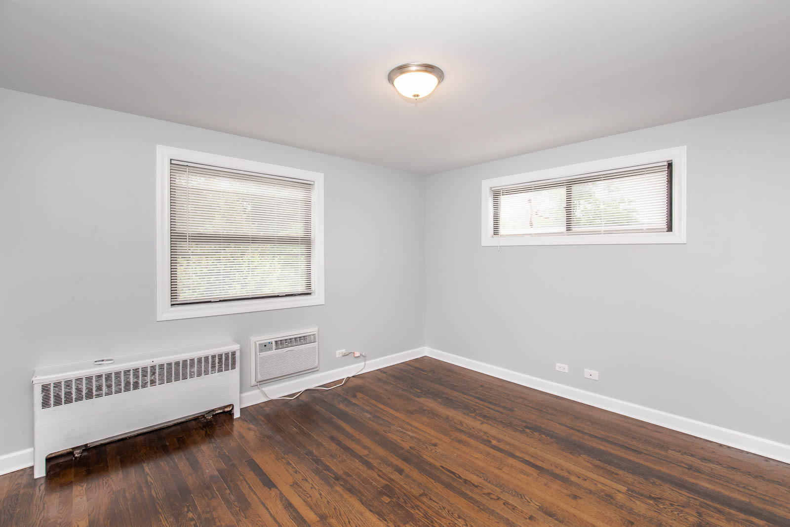 6805 North Ridge Boulevard, Unit 104 Chicago, IL 60645 - Photo 6 of 11 a view of an empty room with wooden floor and a window