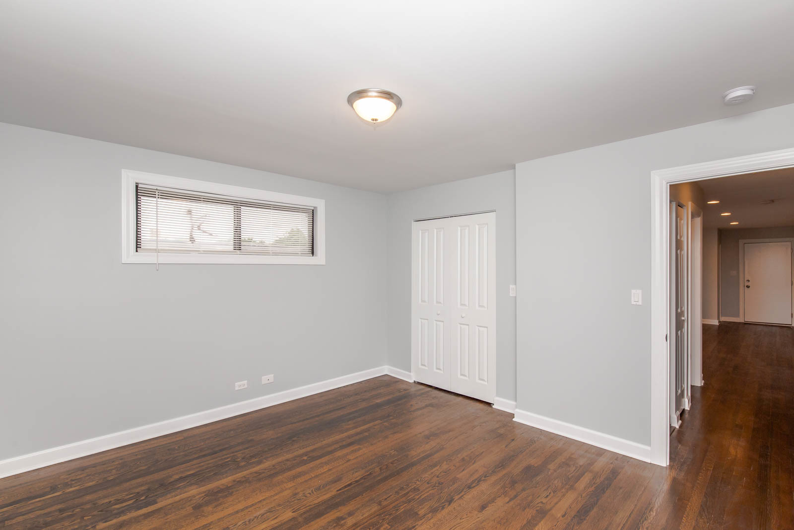 6805 North Ridge Boulevard, Unit 104 Chicago, IL 60645 - Photo 7 of 11 a view of an empty room with wooden floor and a window