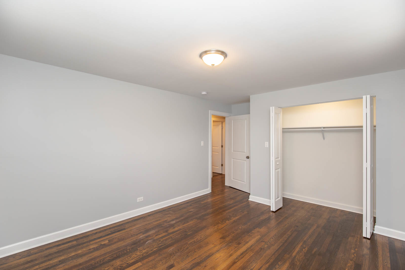 6805 North Ridge Boulevard, Unit 104 Chicago, IL 60645 - Photo 9 of 11 a view of an empty room with wooden floor and closet