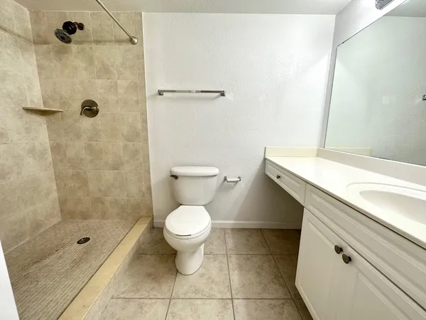 a bathroom with a granite countertop sink toilet and shower