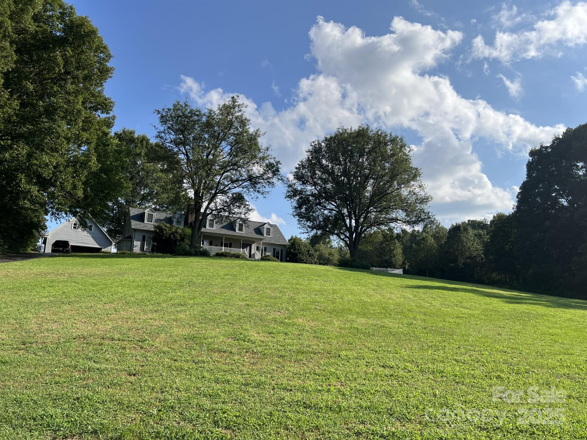 331 Polk Ford Road Stanfield, NC 28163 - Photo 2 of 33 a view of a field of grass and trees
