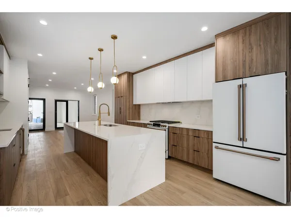 a kitchen with stainless steel appliances sink refrigerator and wooden floor