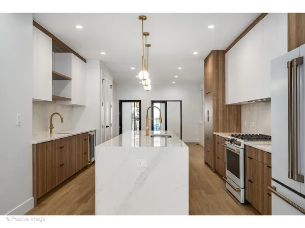 a kitchen with stainless steel appliances kitchen island granite countertop a stove a sink a refrigerator and a refrigerator