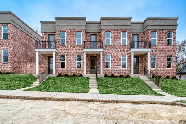 front view of a brick house with a yard