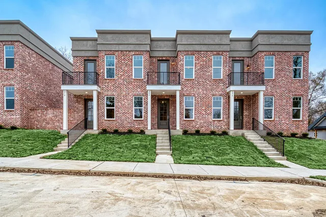 front view of a brick house with a yard