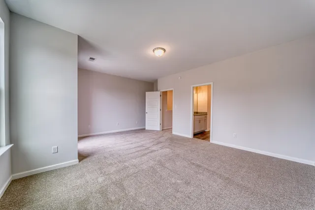 an empty room with closet and mirror