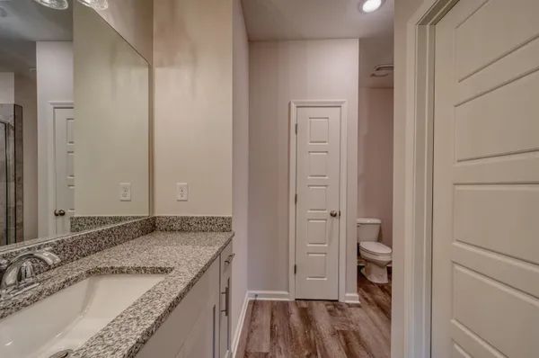 a bathroom with a granite countertop sink and a mirror