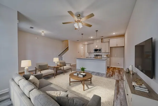 a living room with furniture kitchen view and a chandelier