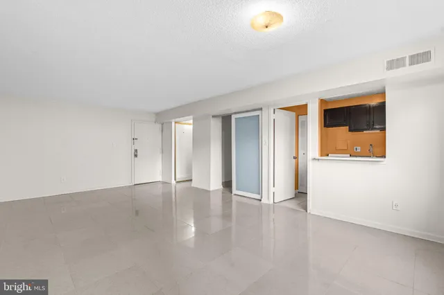a view of a hallway with a livingroom and a bathroom