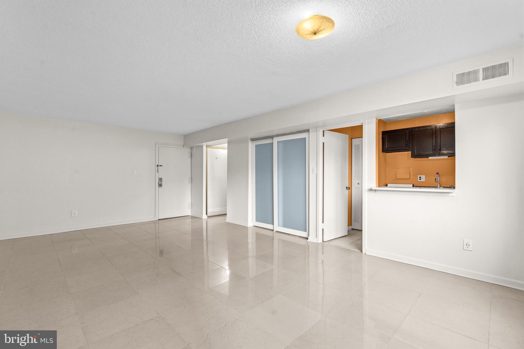 1836 Metzerott Road, Unit 215 Hyattsville, MD 20783 - Photo 15 of 36 a view of an empty room with wooden floor and a window