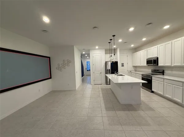 a large kitchen with stainless steel appliances kitchen island granite countertop a refrigerator a stove a sink and a microwave