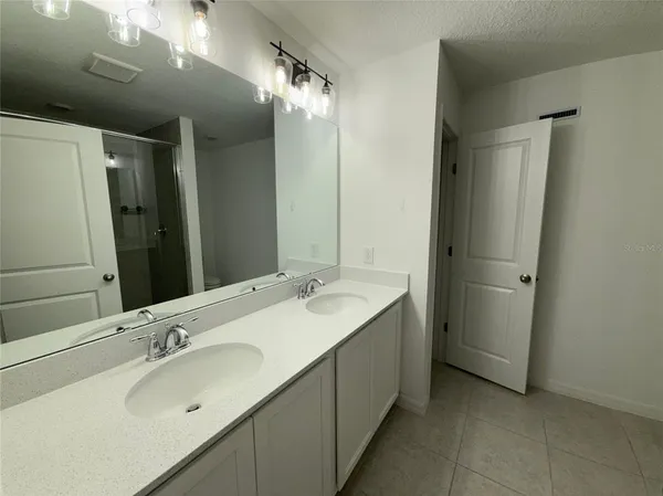 a bathroom with a double vanity sink and a mirror