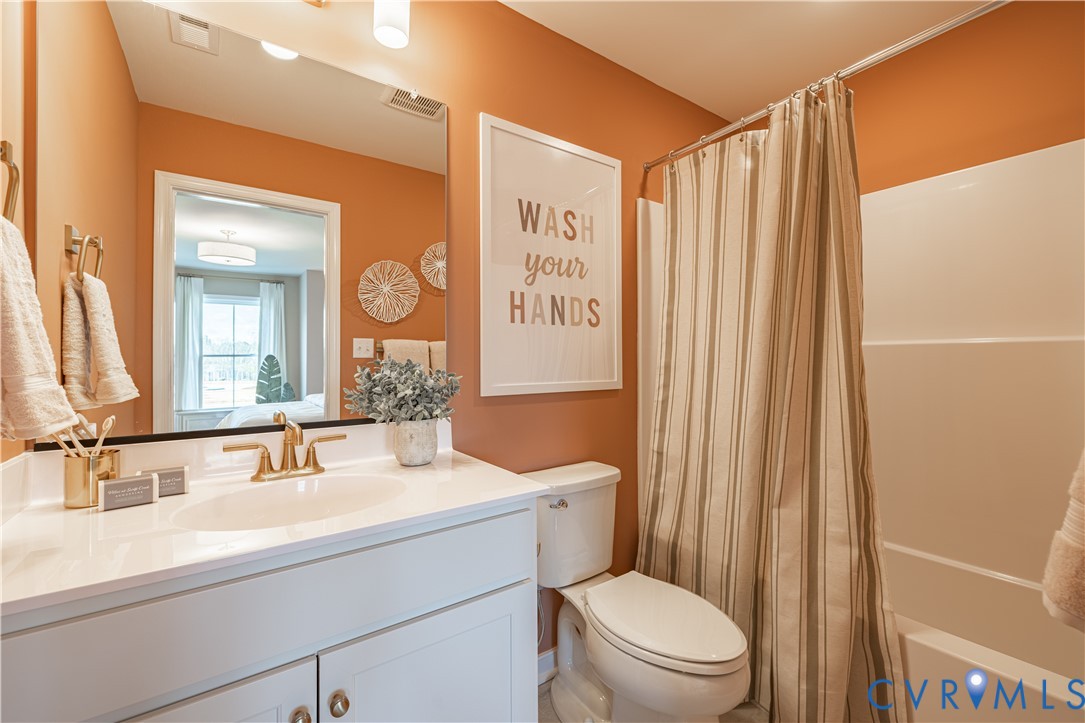 6710 Mayland Rdg Lane; Moseley, VA 23120 - Photo 16 of 16 a bathroom with a sink a toilet a mirror and shower curtain
