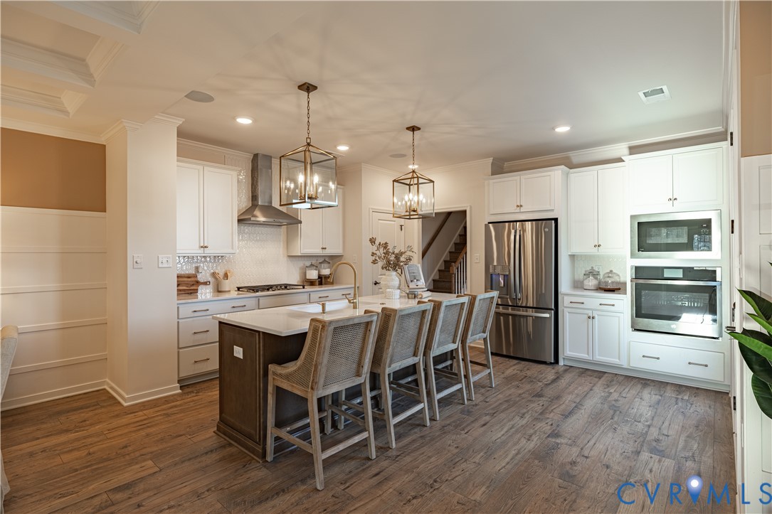 6710 Mayland Rdg Lane; Moseley, VA 23120 - Photo 5 of 16 a kitchen with stainless steel appliances a dining table chairs stove refrigerator and microwave