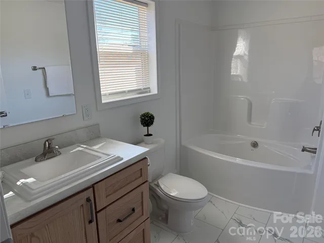 a bathroom with a sink toilet vanity and bathtub