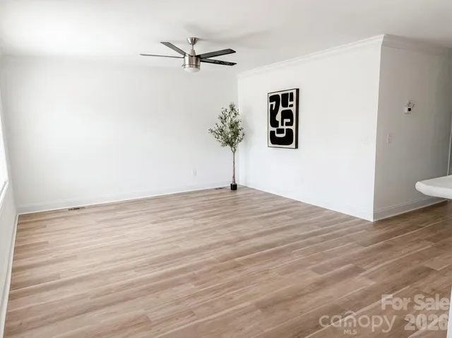 a view of a room with wooden floor and white walls