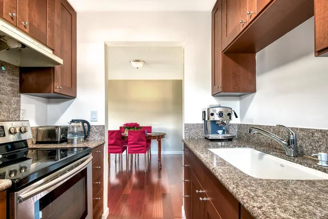 a kitchen with stainless steel appliances granite countertop a sink stove and cabinets