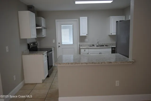 a kitchen with a sink a stove and cabinets