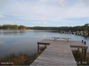 7th Loop Silver Springs, FL 34488 - Photo 2 of 10 a view of a lake with a bench and lake view