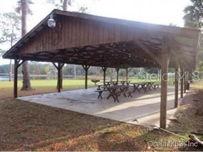 7th Loop Silver Springs, FL 34488 - Photo 5 of 10 a view of a patio with a table and chairs under an umbrella with a small yard
