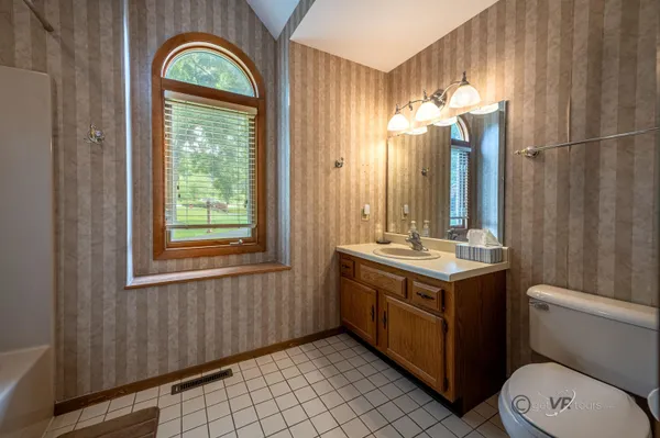 a bathroom with a granite countertop sink a toilet and a mirror