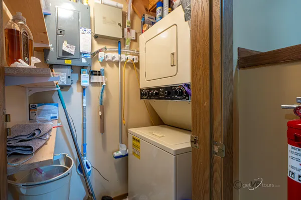 a utility room with dryer washer and a view of living room
