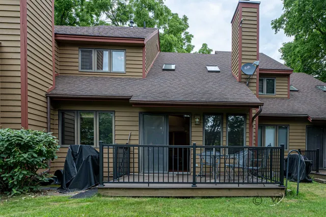 a balcony with wooden floor table and chairs
