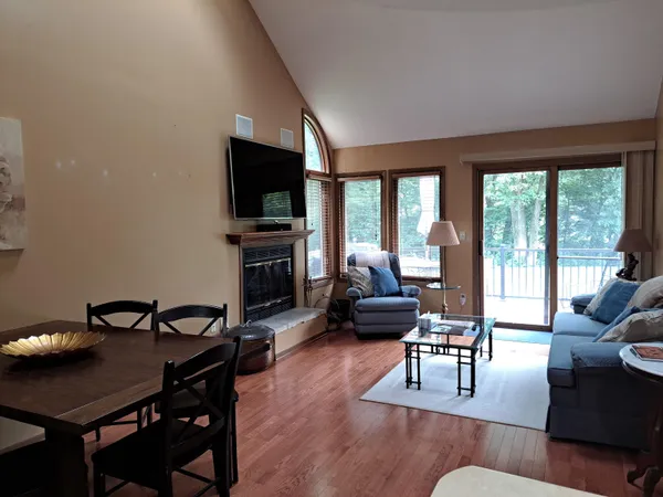 a living room with furniture a flat screen tv and a large window