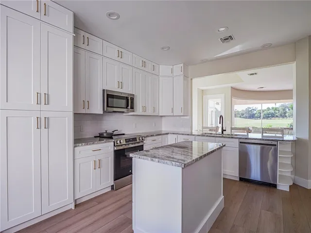 a kitchen with granite countertop a sink and steel appliances