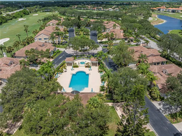an aerial view of residential houses with outdoor space and lake view