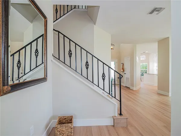 a view of staircase with lots of frames on wall and wooden floor