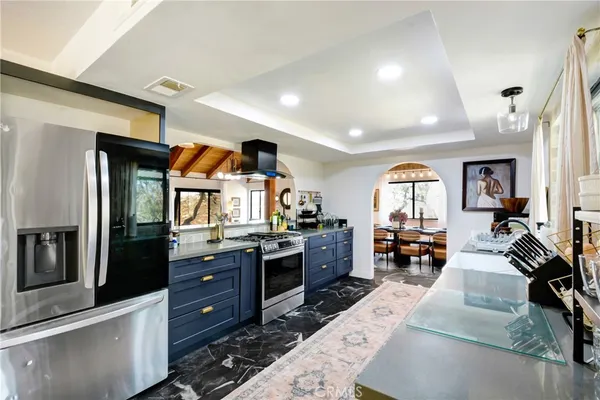 a kitchen with stainless steel appliances granite countertop sink stove and refrigerator