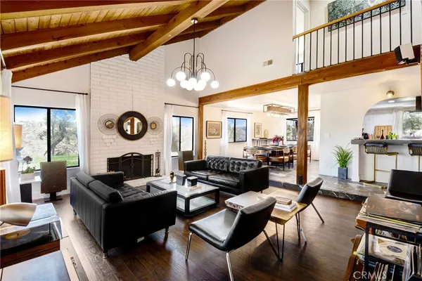 a living room with furniture kitchen view and a large window