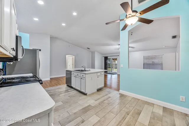 a kitchen with white cabinets and stainless steel appliances