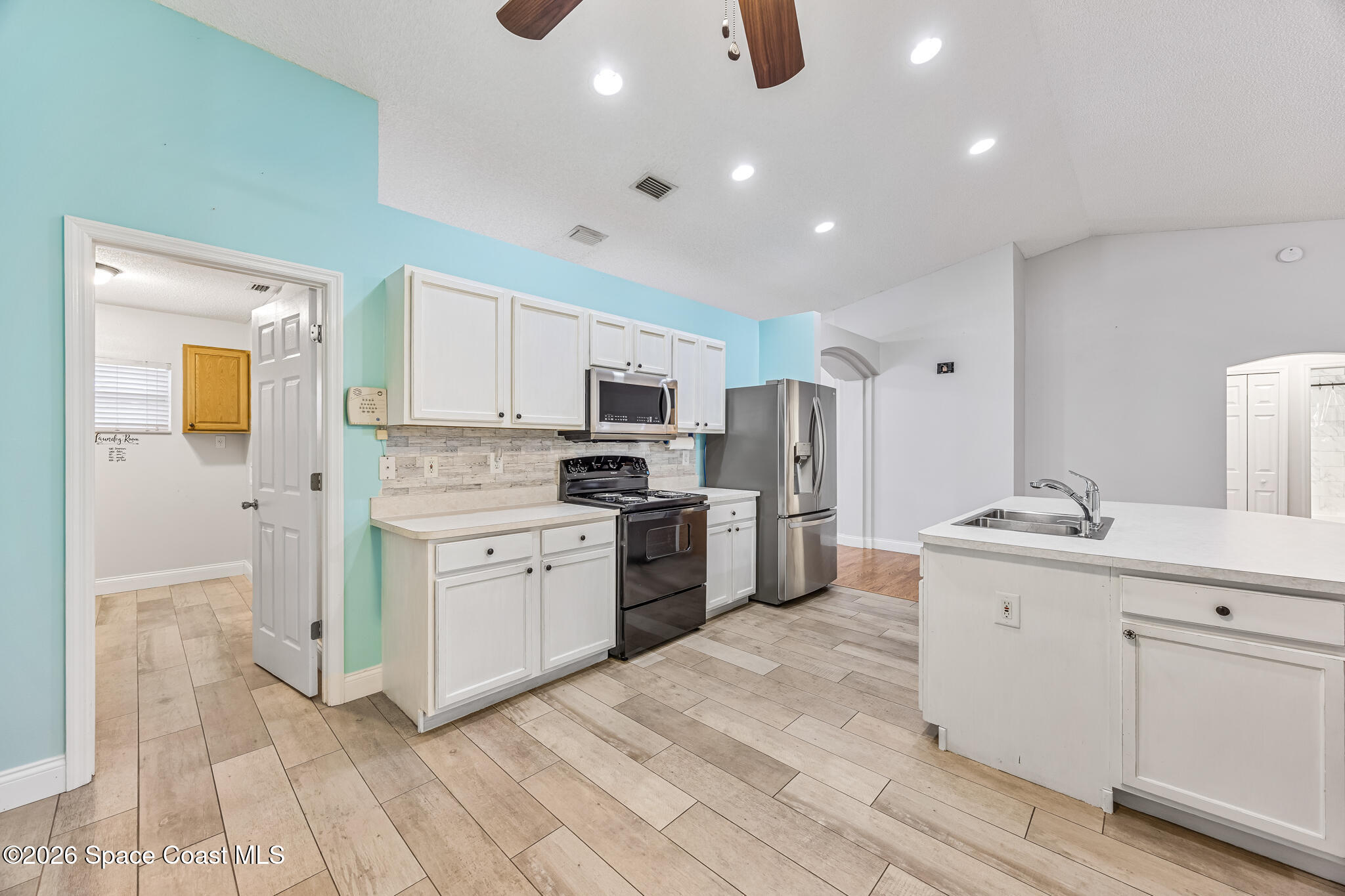 6185 Degan Road Cocoa, FL 32927 - Photo 12 of 30 a kitchen with white cabinets and stainless steel appliances